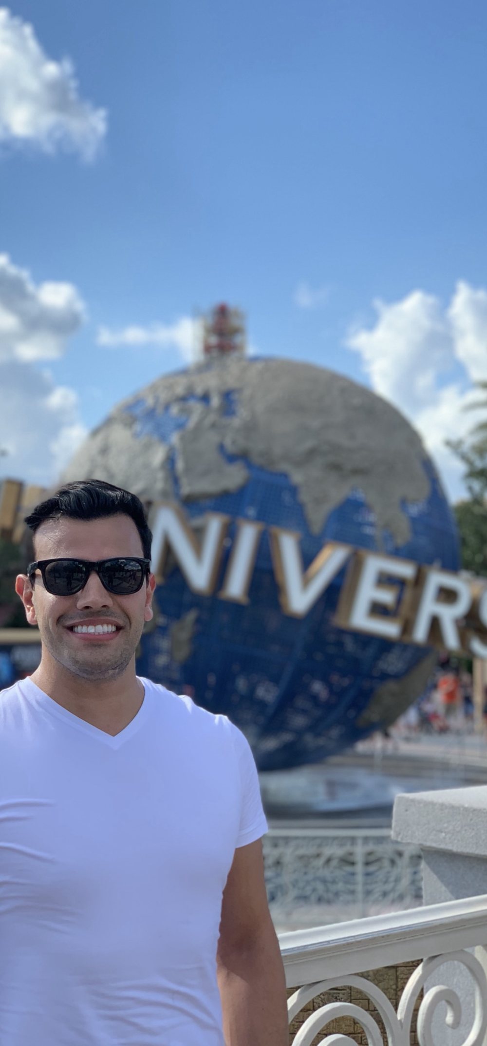 Daniel Malinoski sorrindo, de óculos escuros, em viagem